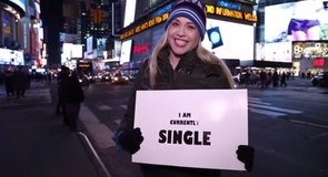 Clich: „Musisz się tam znaleźć”. Wyzwanie: Spaceruj po Nowym Jorku z tabliczką z napisem „Obecnie jestem SINGIEL”.
