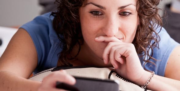 Foto von einem Mädchen, das auf ihrem Handy eine SMS schreibt