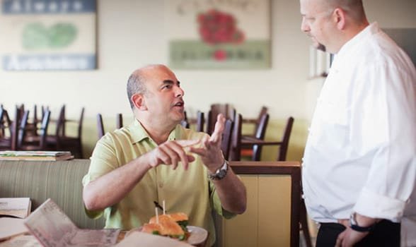 Foto di un uomo che urla contro un cameriere
