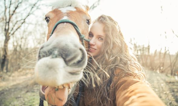 Foto de una mujer tomando una foto con un caballo