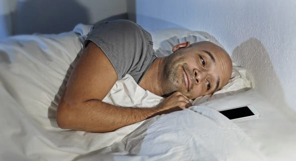 Foto di un uomo che dorme con il suo telefono
