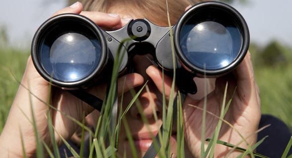 Fotografie ženy dívající se dalekohledem