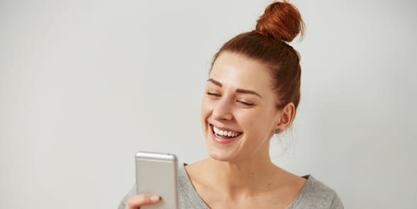 Photo d'une femme tenant un téléphone portable et riant