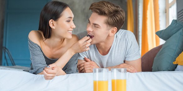Foto de una pareja desayunando en la cama
