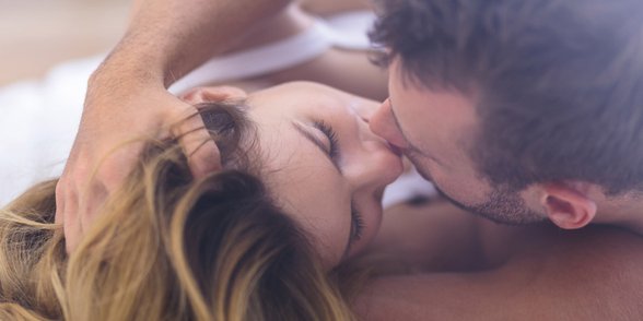 Foto von einem Paar, das sich im Bett küsst