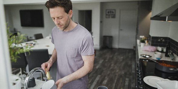 Foto de un hombre lavando los platos