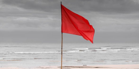 Foto einer roten Flagge am Strand