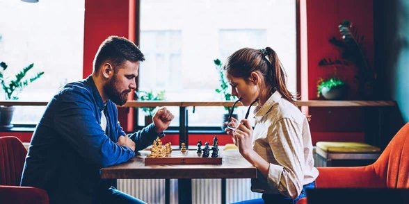 Photo d'un couple jouant aux échecs