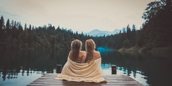 Foto van lesbisch koppel aan een meer