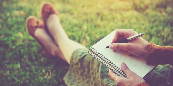 Foto einer Frau, die in ein Tagebuch schreibt