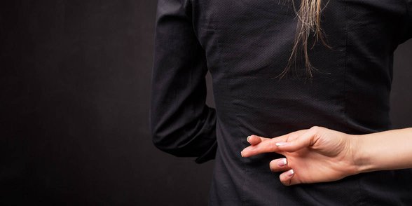 Zdjęcie kobiety ze skrzyżowanymi palcami za plecami